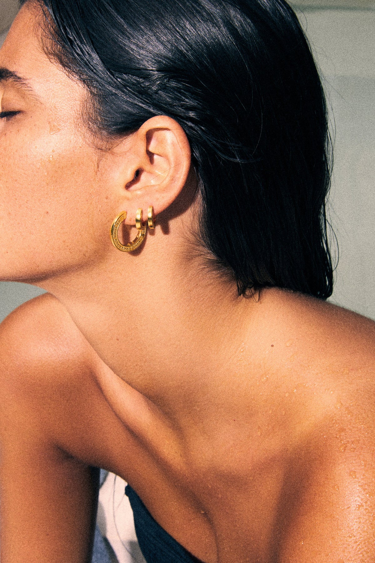Side profile of woman wearing engraved earrings gift guide for stylish jewelry selection.