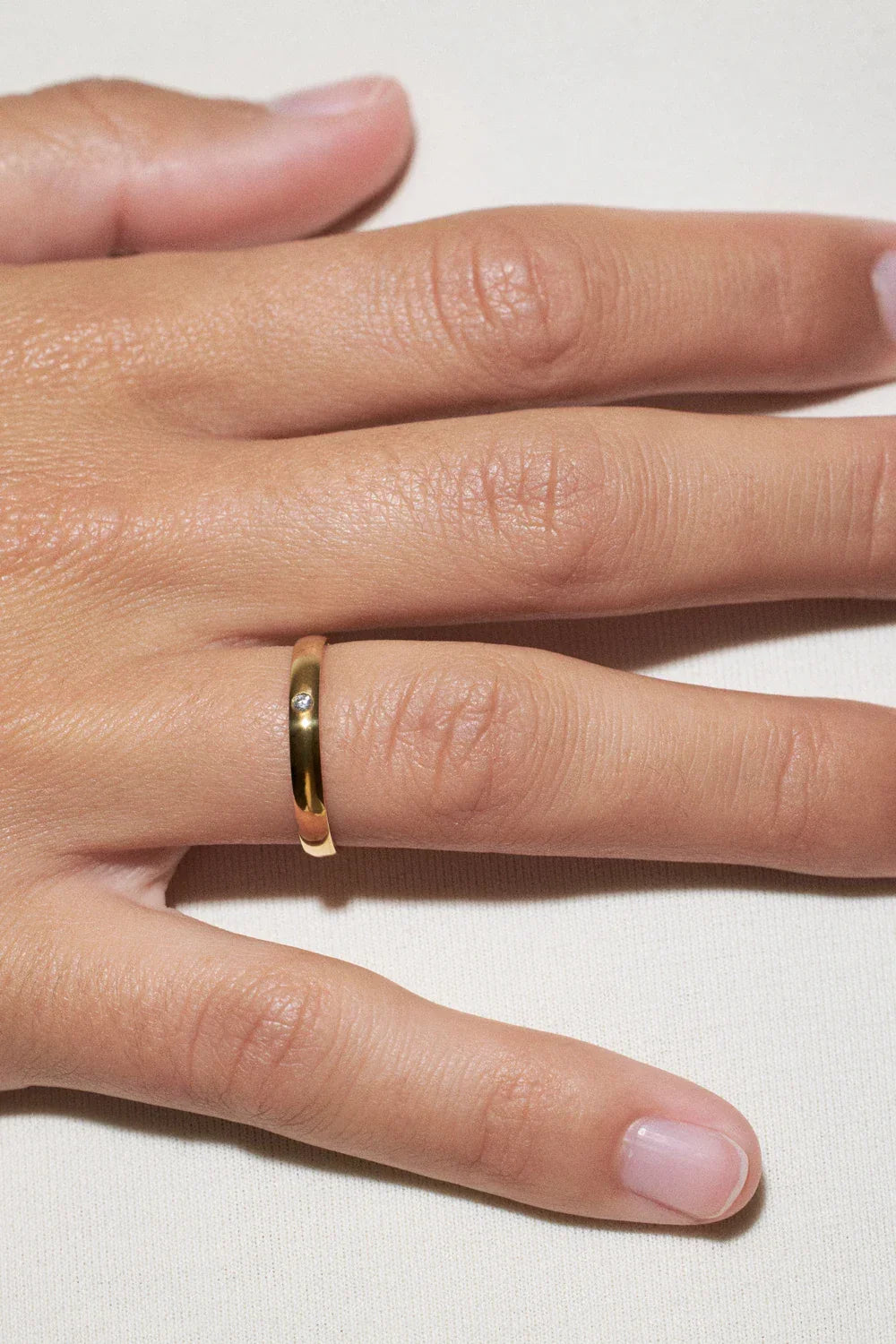 minimalist wedding rings selection: gold band on hand