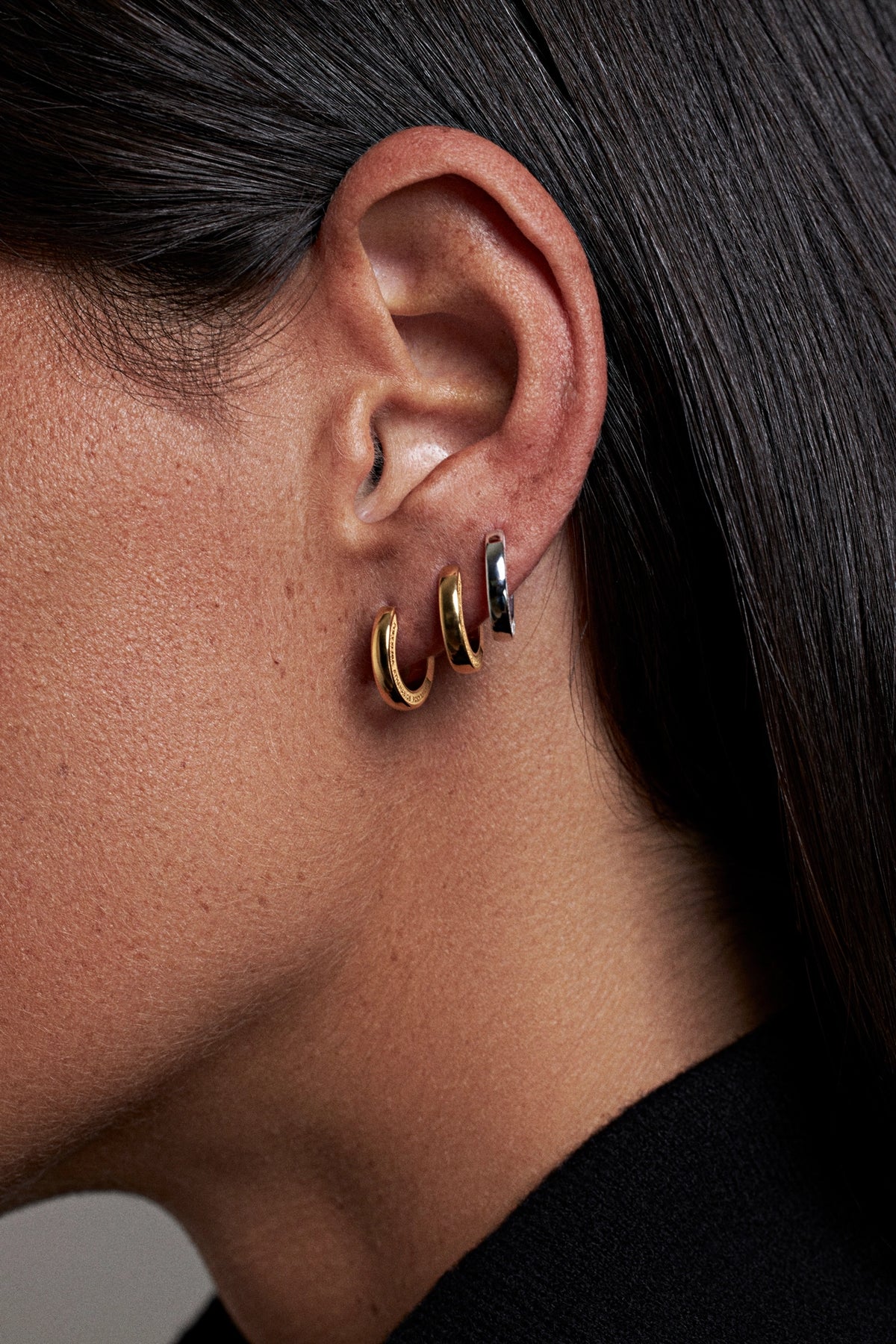 CINCO hoop-earrings-gold-and-silver-worn-on-ear-side-view