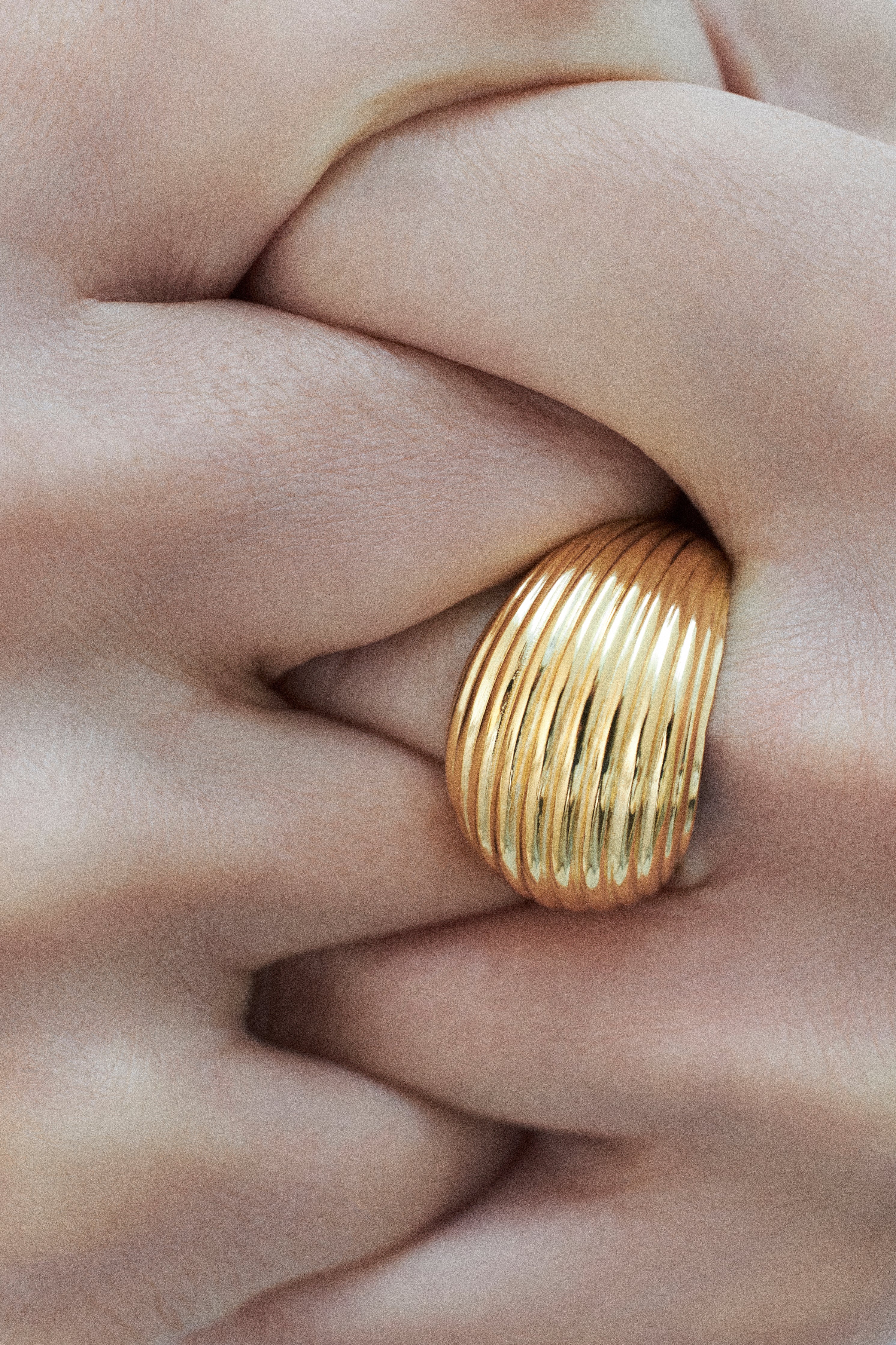 Gold ring on a finger with a close-up view of skin texture