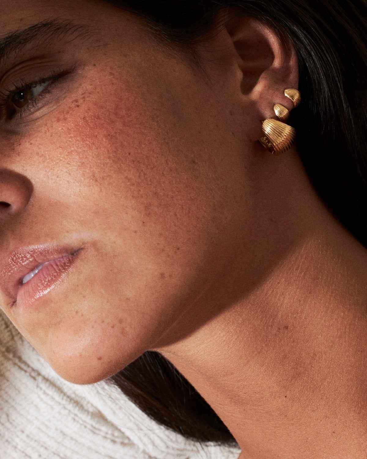 Close-up of a woman wearing elegant earrings, illustrating the beauty of jewelry in the context of Joias em prata valem o investimento.