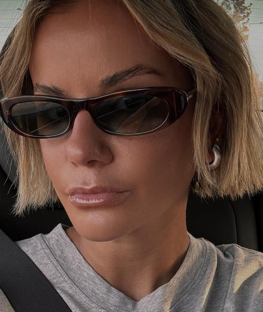 Close-up of a person wearing sunglasses and a stylish attire, showcasing a contemporary look.
