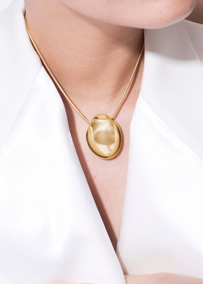 Handmade elegant Chéri necklace displayed on a model against a white background, highlighting its unique pendant design.