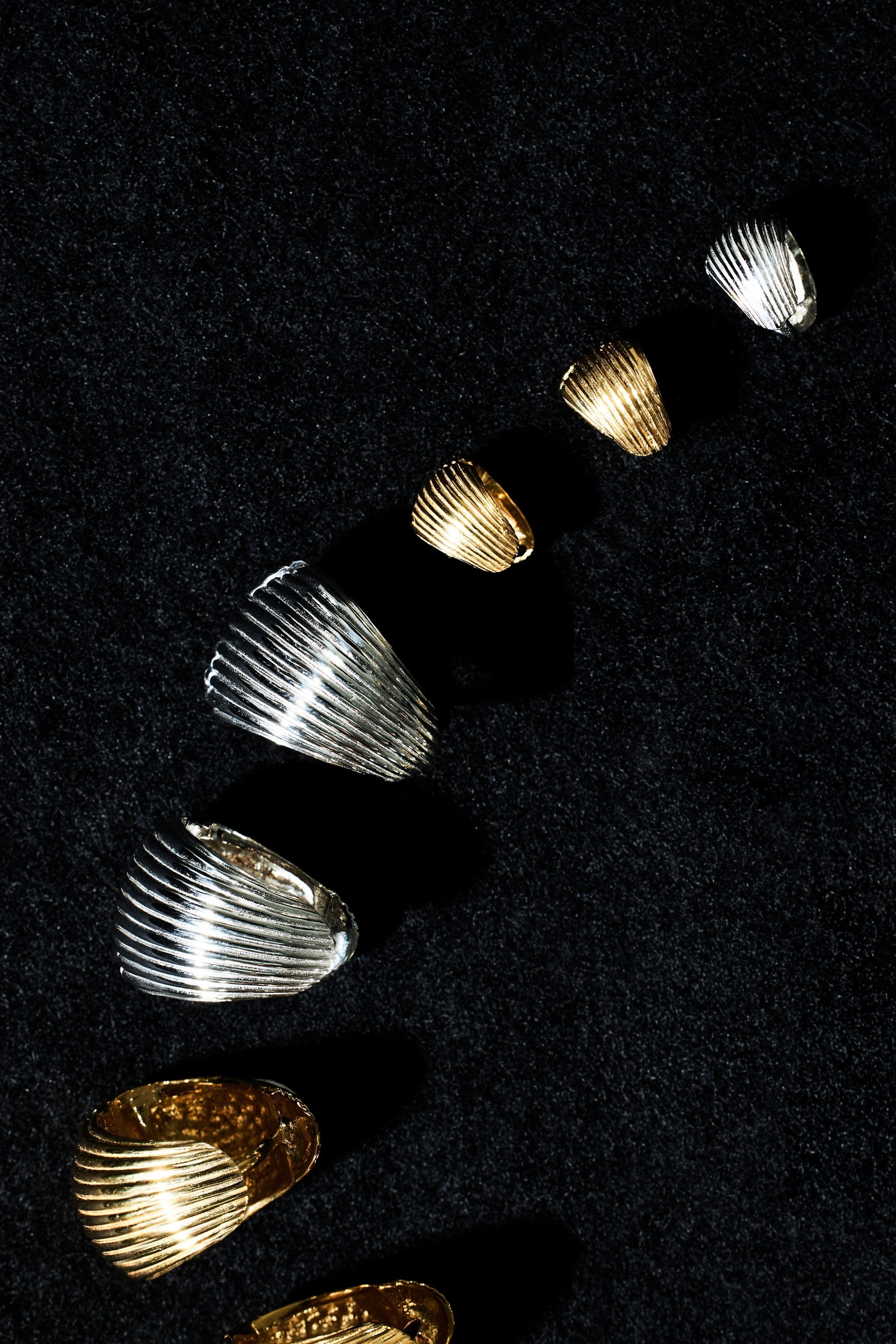 Set of gold and silver rings on a black background