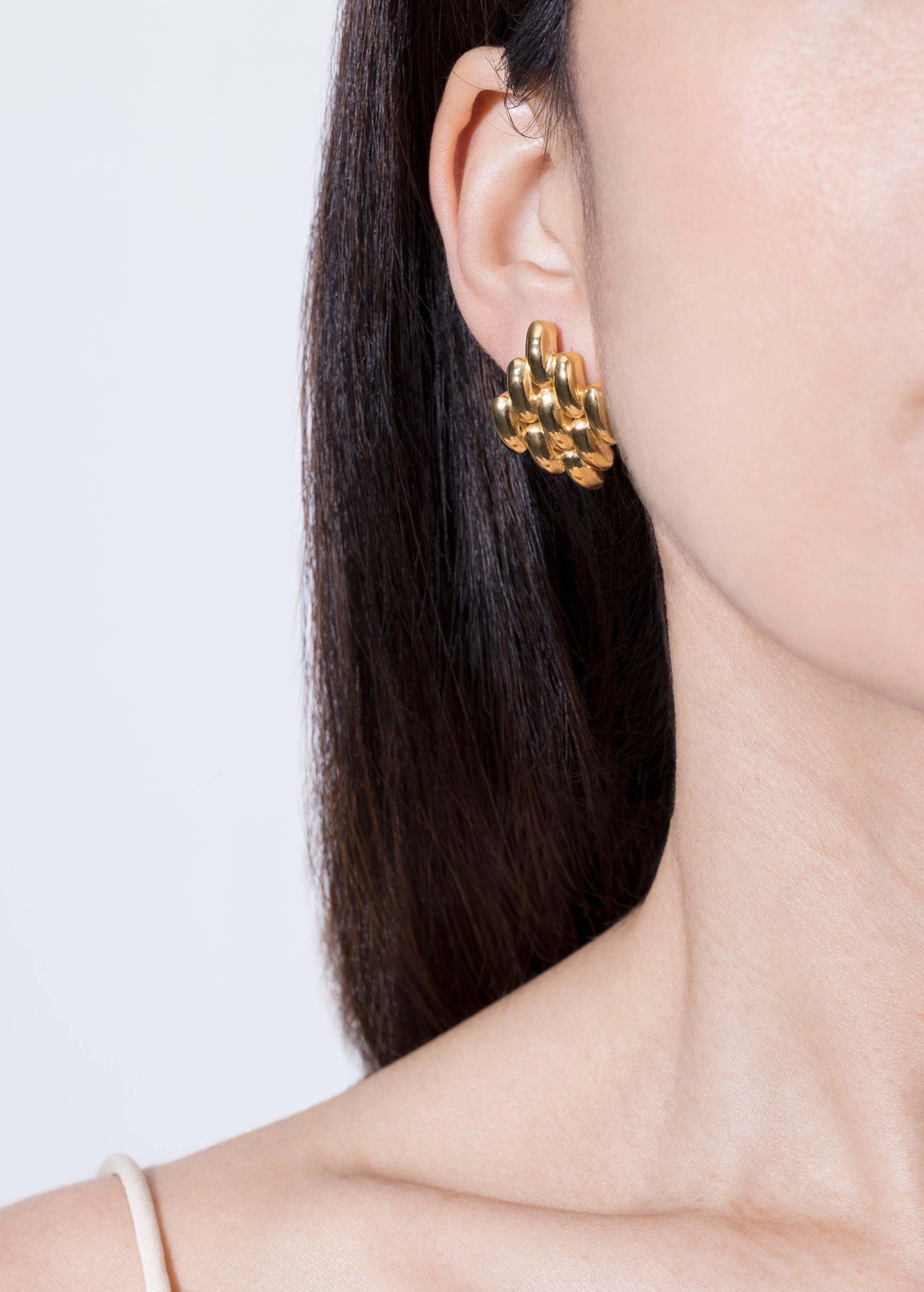 model wearing gala earrings in gold 