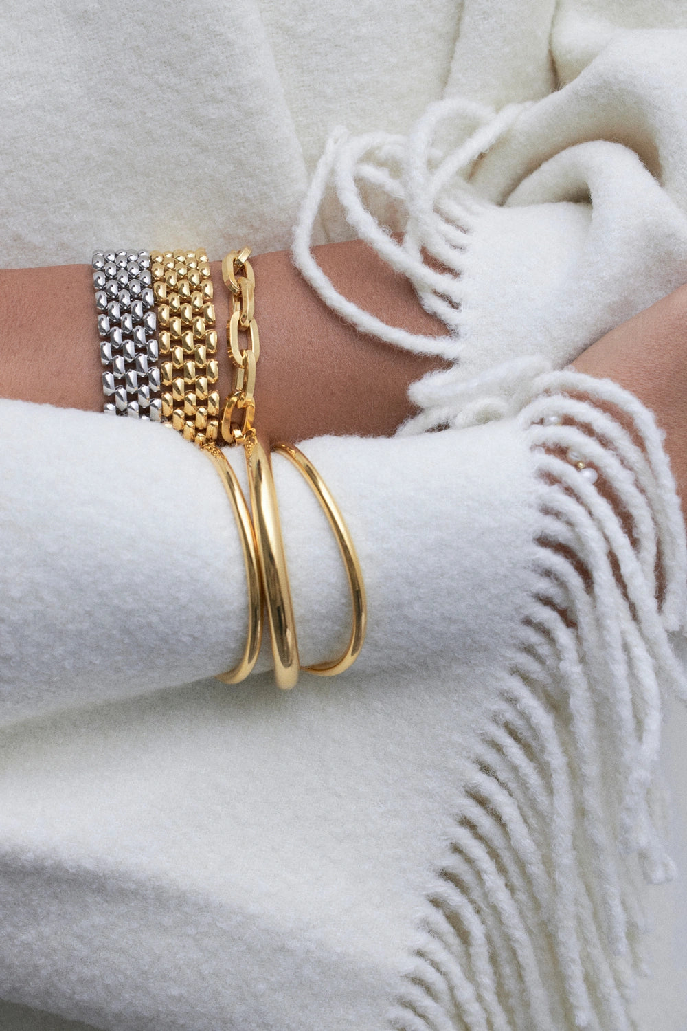 model wearing multiple gol bracelets
