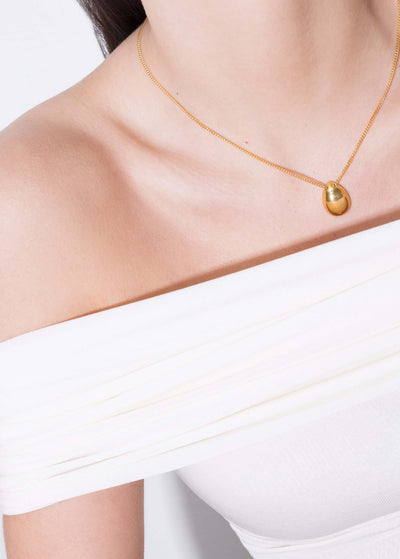 Model showcasing Klein Pearl Double Side Necklace with a delicate gold chain on a white off-shoulder top.