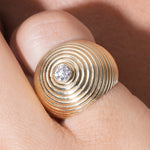 Gold ring with a diamond on a pinky finger